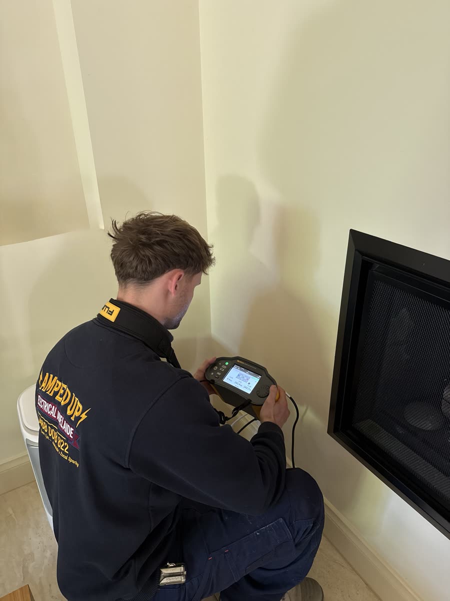 Marcus taking live test readings with a Fluke installation tester on an Adelaide job
