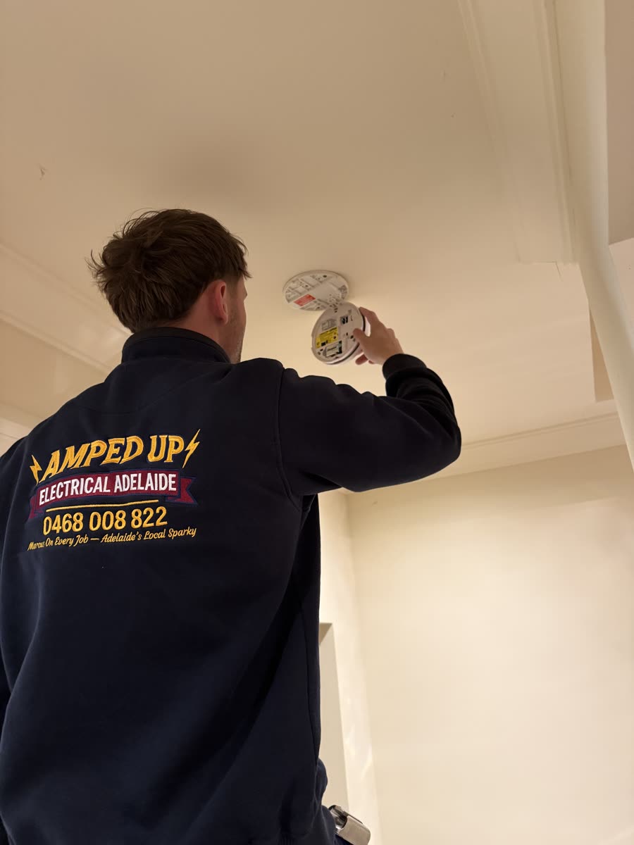 Marcus replacing a ceiling-mounted smoke alarm in an Adelaide home