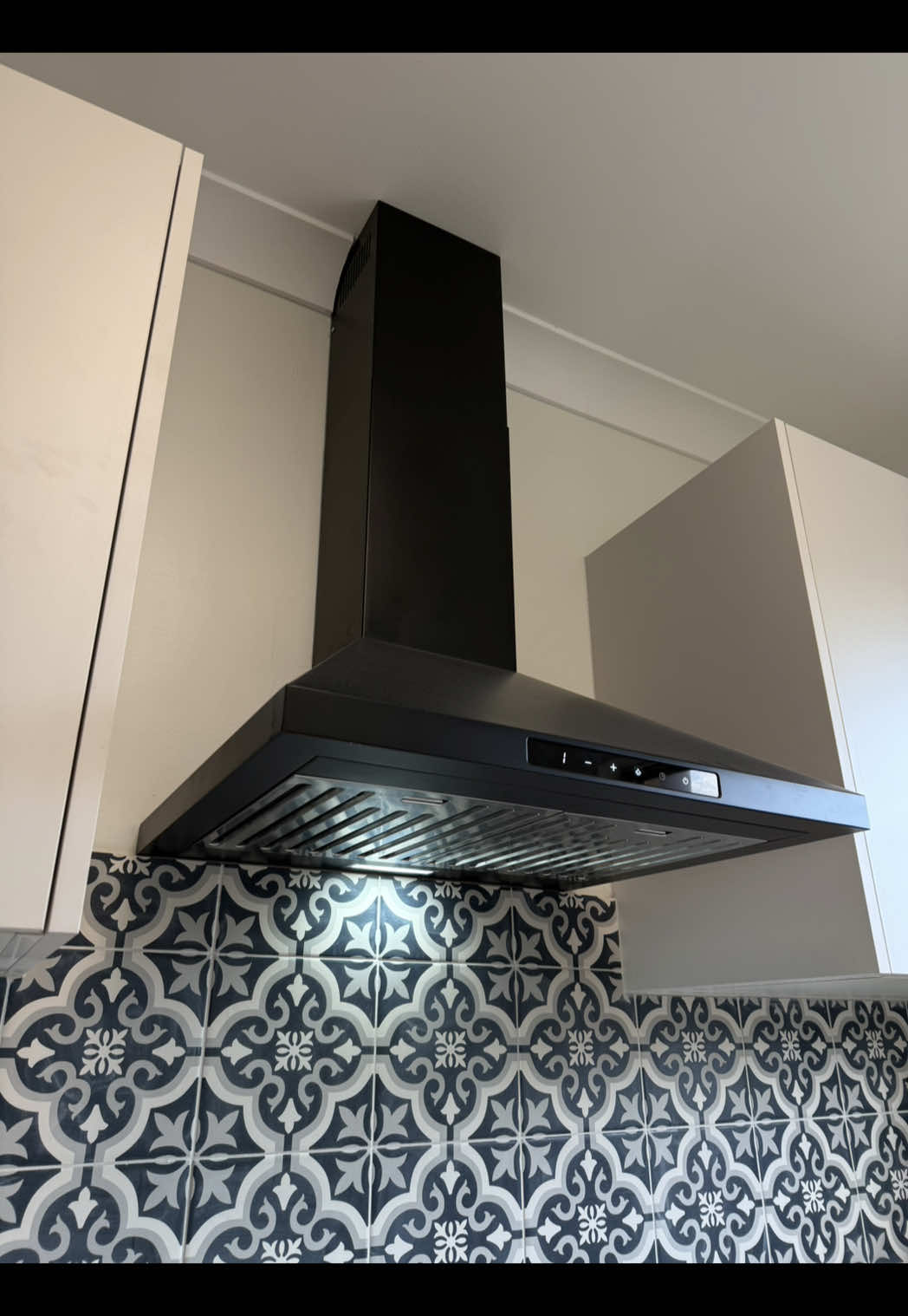 Black canopy rangehood installed above a patterned tile splashback in a Payneham kitchen renovation