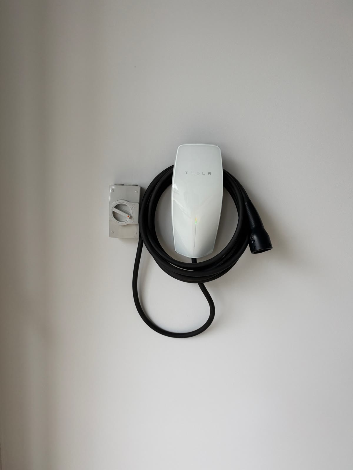 Tesla Wall Connector in a Campbelltown garage with the isolator beside it and the cable hidden in the wall