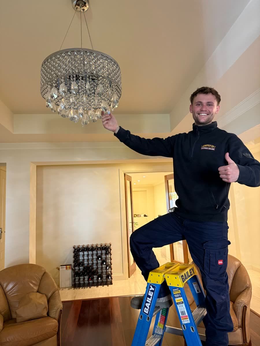Marcus hanging a crystal chandelier